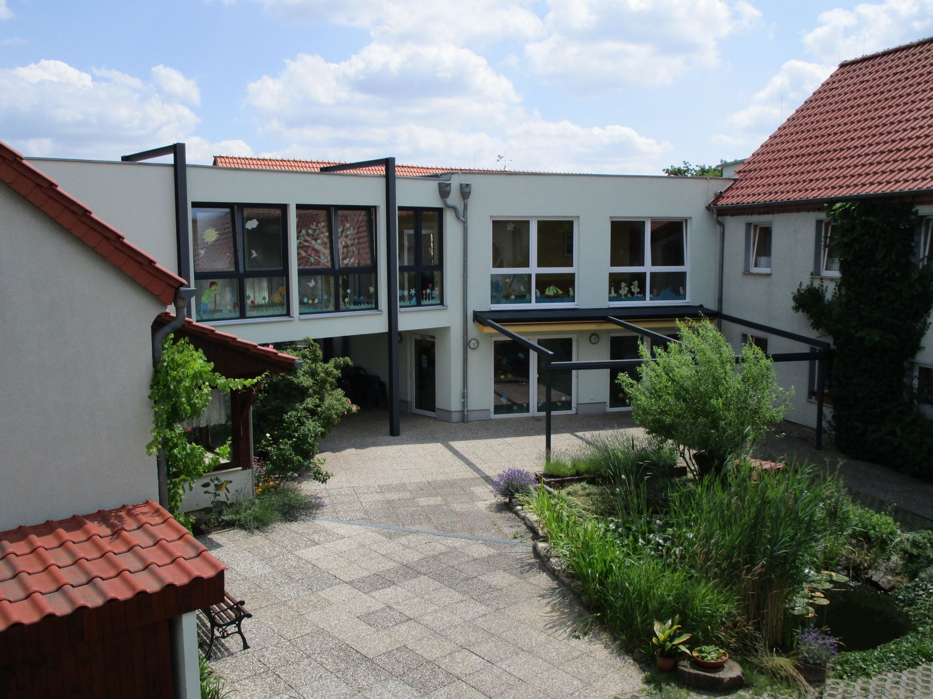 Innenhof mit einem Gebäude im Hintergrund, das eine ruhige und gepflegte Atmosphäre ausstrahlt.
